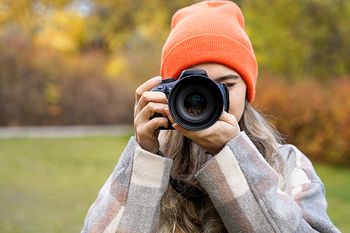 一眼レフカメラを構えている女性