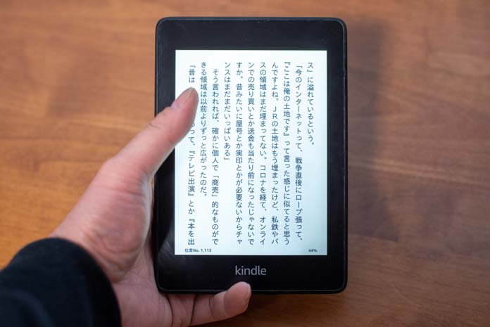 Kindle PaperWhiteを手で持って、読書をしている