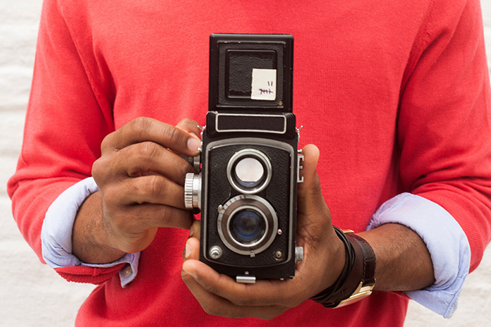 二眼レフカメラを構えている